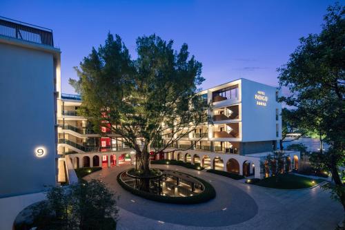 a building with a tree in the middle of a courtyard at Hotel Indigo Guangzhou Haixinsha by IHG - Free Shuttle Bus to Canton Fair Complex during Canton Fair period in Guangzhou