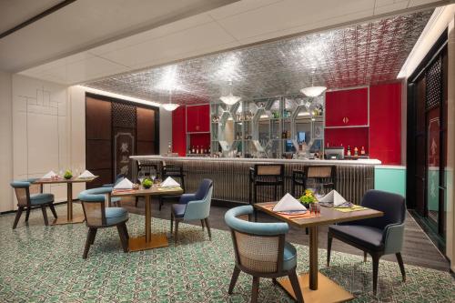 a restaurant with tables and chairs and a kitchen at Hotel Indigo Guangzhou Haixinsha by IHG - Free Shuttle Bus to Canton Fair Complex during Canton Fair period in Guangzhou