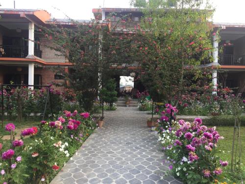 a garden with flowers and a walkway at Chautari Garden Resort in Sauraha