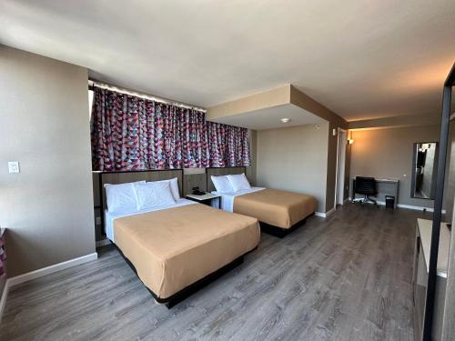 a hotel room with two beds and a window at Regal Inn & Suites New York LaGuardia Hotel in Flushing