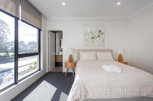 a bedroom with a large bed with two towels on it at Westside Retreat in Perth