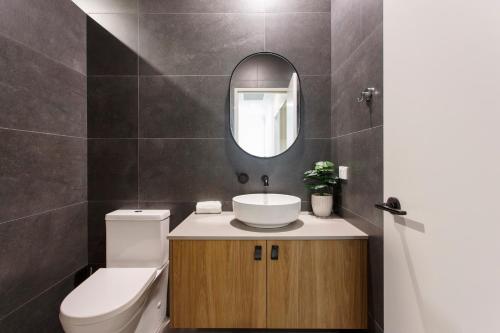 a bathroom with a toilet and a sink and a mirror at Westside Retreat in Perth