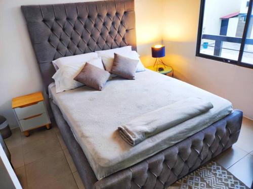 a bedroom with a large bed with a leather headboard at NUEVA Hermosa casa vía Samborondón Coliving Ecuador in Guayaquil