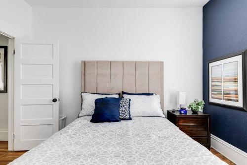 a bedroom with a large bed with blue walls at Chic Urban Couples Retreat: Perfect Getaway 'n RVA in Richmond