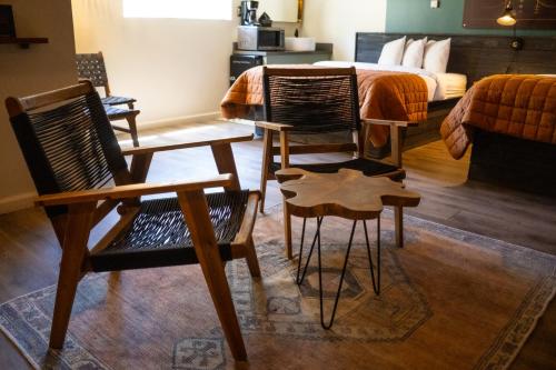 two chairs and a table in a room with a bed at Sessions Retreat & Hotel in Big Bear Lake