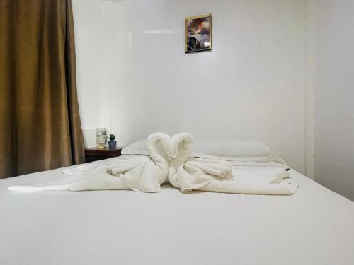 Una cama blanca con un montón de toallas. en Dolce Vita Resort en Moalboal