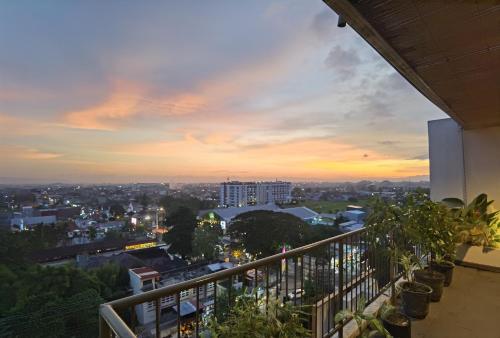 a view of a city at sunset from a balcony at Student Park Hotel in Yogyakarta