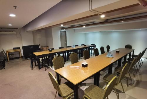 a row of tables and chairs in a room at Student Park Hotel in Yogyakarta
