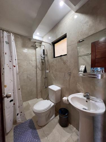 a bathroom with a toilet and a sink at Infinity Diving Resort and Residences in Dauin