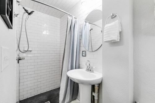 a white bathroom with a sink and a shower at Charming, Happy 1-Bed Oasis: RVA Retreat Awaits! in Richmond