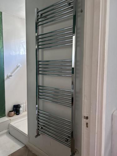 a bathroom with a shower with a metal shutter at Home from home, close to Redditch hospital & transport links in Redditch