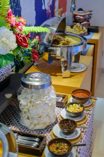 a buffet with bowls of food on a table at Student Park Hotel in Yogyakarta