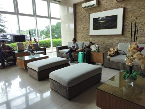 a lobby with a man sitting on a couch at Wind Residences Apt. 1506 Tagaytay in Tagaytay
