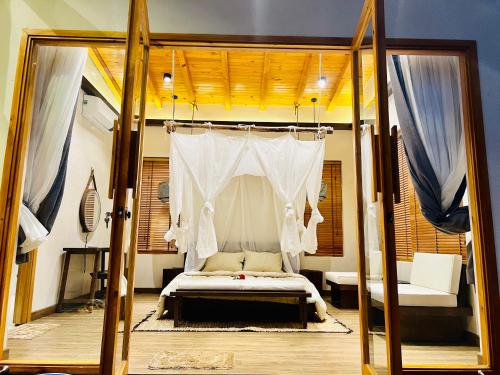 1 dormitorio con 1 cama con dosel en Levillage Bảo Lộc, en Tang Jran Dring