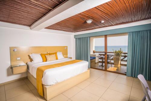 a bedroom with a bed and a view of the ocean at Hotel Los Farallones in La Libertad