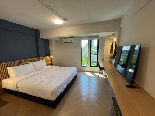 - une chambre avec un lit et une télévision à écran plat dans l'établissement De Botan Bangna, à Bangkok