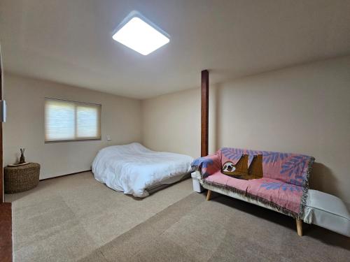 ソギポにあるSamDalChaeのベッドルーム(ベッド1台、ソファ付)