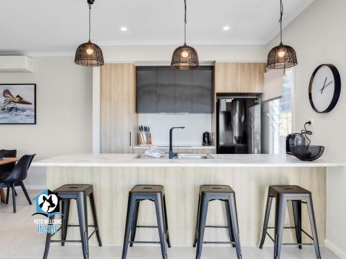 a kitchen with a large island with four bar stools at Brand New 3 Bed 2 Bath with Sea Views in Encounter Bay