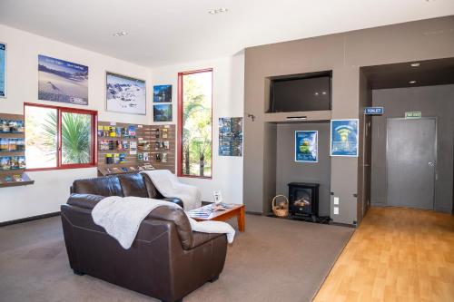 a living room with a couch and a fireplace at Franz Josef TOP 10 Holiday Park in Franz Josef