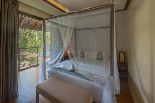 a bedroom with a canopy bed and a balcony at The Hillside Resort Siargao in General Luna