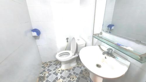 a bathroom with a toilet and a sink and a mirror at Suối giàng A Chông homestay in Yên Bái