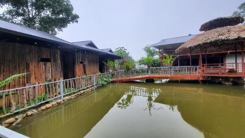 a bridge over a river next to a building at Suối giàng A Chông homestay in Yên Bái