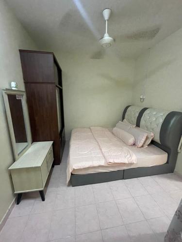 Un dormitorio con una cama y una cómoda. en Nurjah Homestay, en Kuala Terengganu