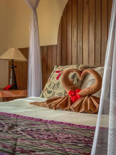 a bed with two pretzels in the shape of a heart at Kukuh House Ubud in Ubud