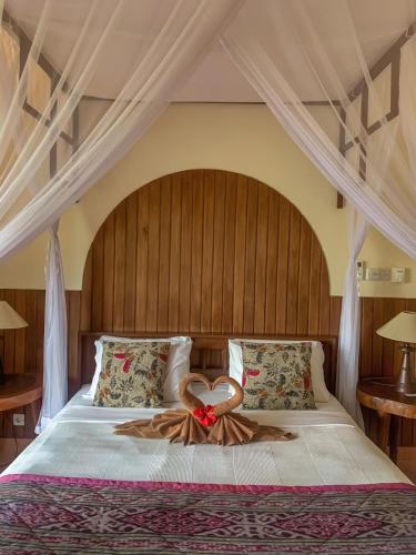 a bed with a heart decoration on it at Kukuh House Ubud in Ubud
