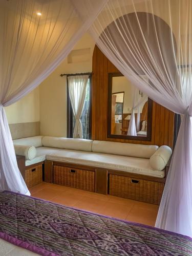 a bedroom with a bed and a mirror at Kukuh House Ubud in Ubud