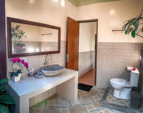 a bathroom with a sink and a toilet at Kukuh House Ubud in Ubud