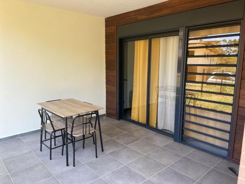 uma mesa e cadeiras na varanda de uma casa em APPARTEMENT T3 COSY et PAISIBLE avec JARDIN à REMIRE-MONTJOLY em Rémiré