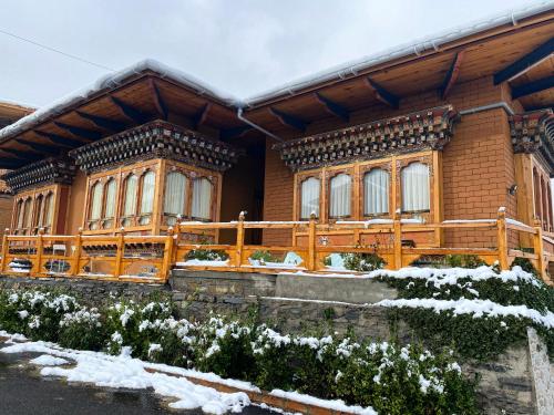 a house with a wooden fence in front of it at Lhayhuel Resort and Spa in Paro