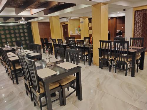 a dining room with black tables and chairs at Hotel S R Castle in Port Blair