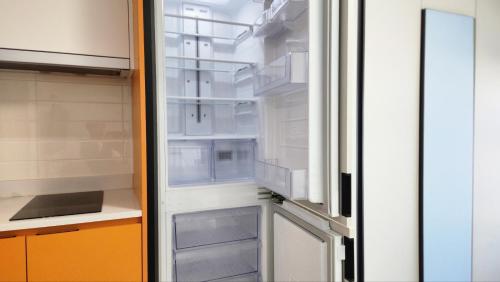an empty refrigerator with its door open in a kitchen at For you House in Daegu