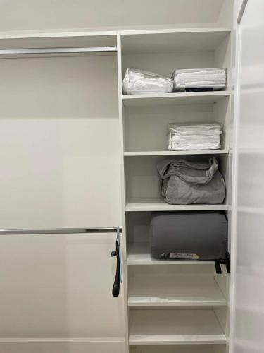 a closet with white shelves and a refrigerator at Gated private house with own parking Sherman Oaks in Los Angeles