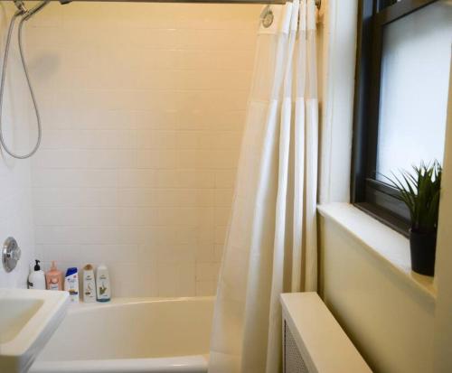 a bathroom with a white tub and a shower curtain at Stunning 3BR Chicago Apt close to Shopping Center in Chicago