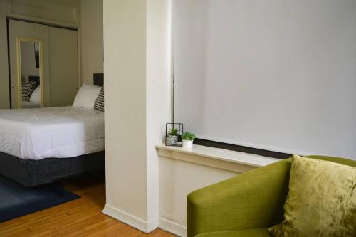 1 dormitorio con 1 cama y 1 silla verde en Stunning 3BR Chicago Apt close to Shopping Center, en Chicago