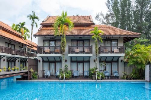un hotel con piscina di fronte a un edificio di Khaolak Oriental Resort - Adult Only a Khao Lak