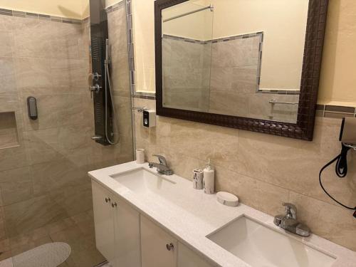 a bathroom with two sinks and a mirror at Luxury Penthouse Suit Red Hills in Kingston