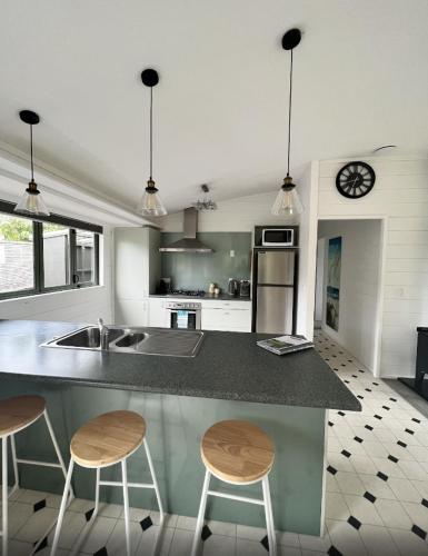 a kitchen with two bar stools and a counter top at Kapanga Escape in Coromandel Town