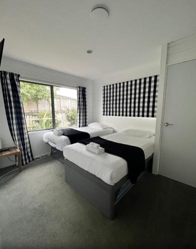 a bedroom with two beds and a window at Kapanga Escape in Coromandel Town
