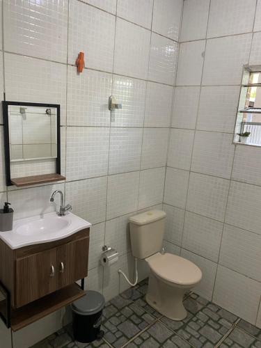 bagno con servizi igienici, lavandino e specchio di Chácara dos Silva a Santa Isabel