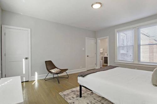 biała sypialnia z łóżkiem i krzesłem w obiekcie Great Location! 15 Min from DT -Historic Hyde Park w Chicago
