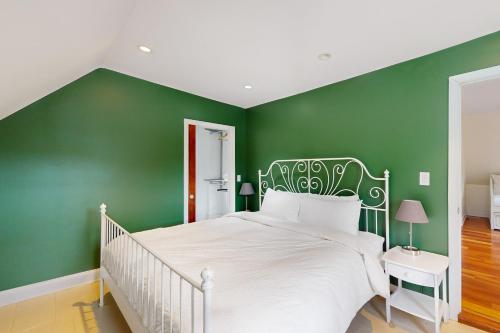 a bedroom with a white bed and green walls at The Sugar House in Bridgewater