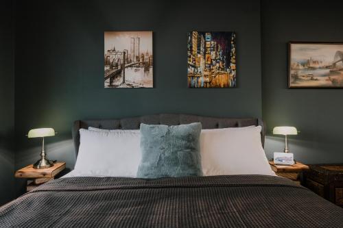 a bedroom with a bed with three pictures on the wall at Twilight Olympic Park 2x King-beds Lux Apt in Sydney
