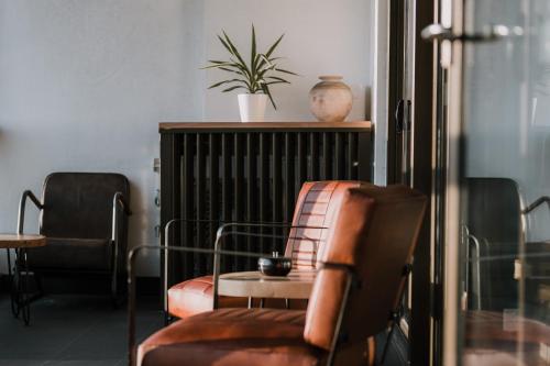 a room with chairs and a table and a plant at Twilight Olympic Park 2x King-beds Lux Apt in Sydney