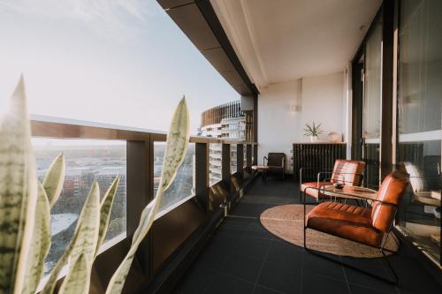 - une vue depuis le haut d'un bâtiment avec une chaise et une table dans l'établissement Twilight Olympic Park 2x King-beds Lux Apt, à Sydney