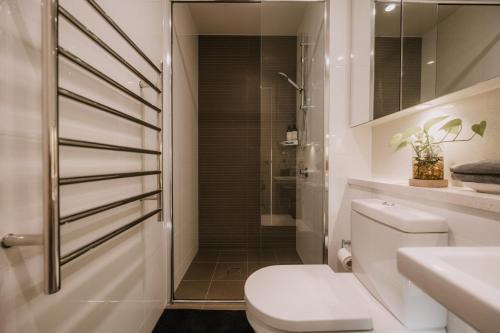 a bathroom with a toilet and a shower at Twilight Olympic Park 2x King-beds Lux Apt in Sydney