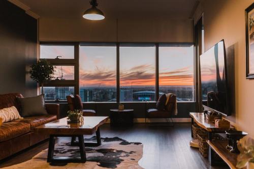 a living room with a couch and a large window at Twilight Olympic Park 2x King-beds Lux Apt in Sydney